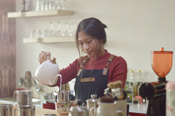 portrait of asian woman pouring hot water to vietnam drip coffee with water jug