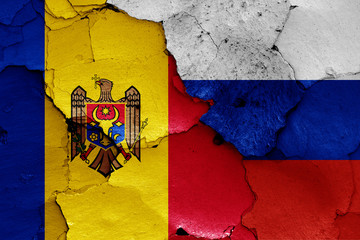 flags of Moldova and Russia painted on cracked wall