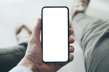 Foto op Canvas Mockup image blank white screen cell phone.men hand holding texting using mobile  background empty space for advertise text.people contact marketing business and technology  © panitan