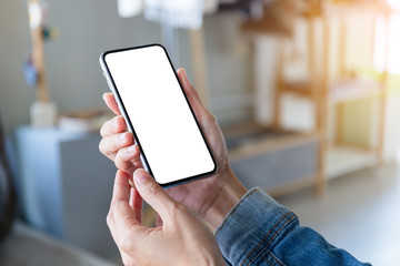 Mockup image blank white screen cell phone.men hand holding texting using mobile on desk at home office. background empty space for advertise text.people contact marketing business and technology 