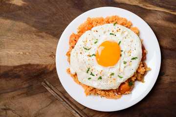 Kimchi fried rice with fried and chopsticks on wooden background, Korean food, top view