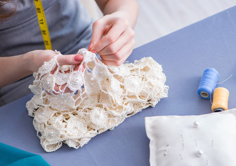 Woman tailor working on a clothing sewing stitching measuring fa