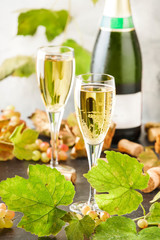 Champagne, brut or sparkling wine in glass on gray background. Autumn still life, wine tasting table setting concept