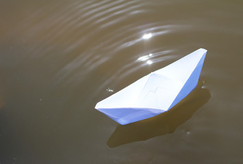 paper boat sailing on water surface