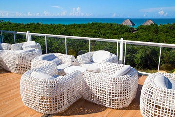 Beautiful, white wicker furniture on the terrace overlooking the sea.Horizontally.