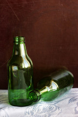 Two green bottles on a brown background. Two small bottles with a narrow neck of green glass on a...