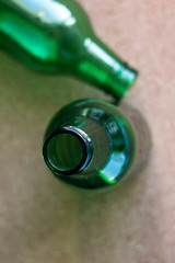 Two green bottles on a brown background. Two small bottles with a narrow neck of green glass on a...