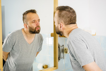 Obraz premium Man looking at himself in mirror