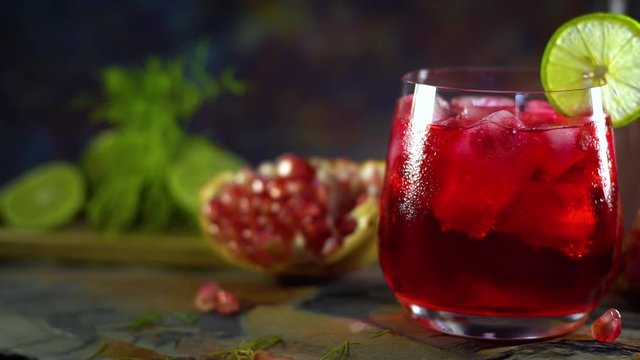 Still life photography of Pomegranate juice lemon soda with pomegranates seeds on table. Shooting at studio,low key toned image, Selective focus and free space for text. Healthy fruits drink concept.