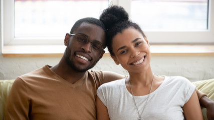 Portrait of happy biracial couple posing for picture hugging - Powered by Adobe