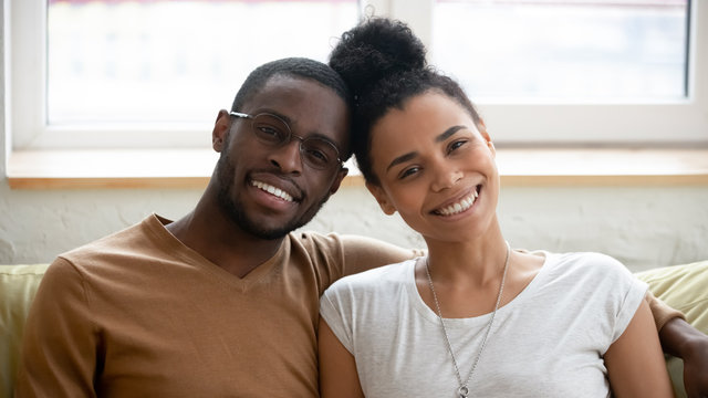 Portrait of happy biracial couple posing for picture hugging