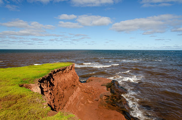 erosion red rocks falling into the ocean on pei island