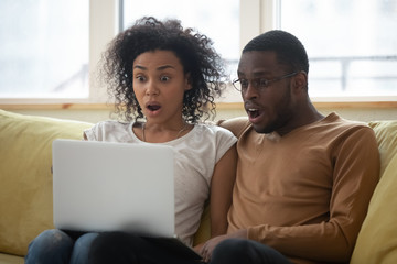 Amazed african American couple shocked by online news