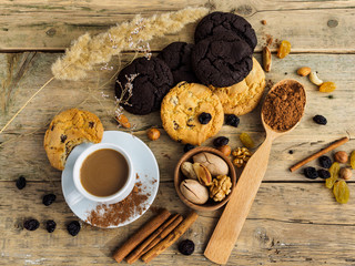 Coffee in a white Cup, sweet biscuits and nuts on a wooden table. Top view of the table