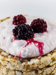The juice of juicy BlackBerry berries flows over the curd dessert on a white background
