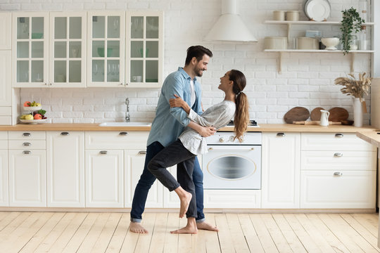 Happy romantic couple dancing in modern kitchen at home