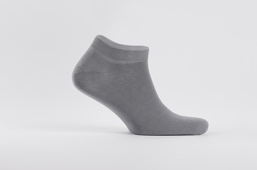 Blank grey cotton short sock on invisible  foot on white background as mock up for advertising, branding, design, side view, template.