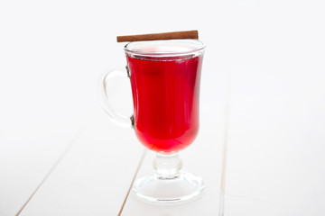 Mulled wine with cinnamon sticks on a white wooden background