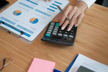 Fototapeta na wymiar financial adviser use calculator to calculate revenue & budget. accountant doing accounting. bookkeeper making calculation