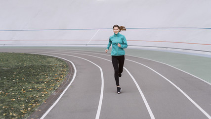 Obraz premium Young adult sporty woman running on sport training in city