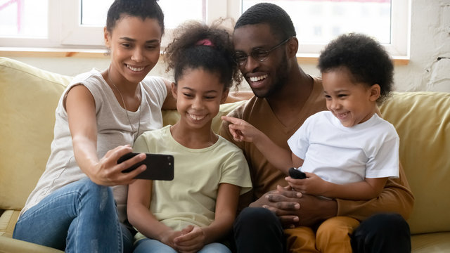 Happy african American family making selfie on smartphone together