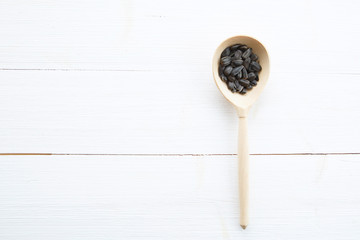 Sunflowers seeds in spoon on white wooden table with clipping path