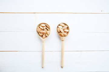 Pumpkin seeds in spoon on white wooden table with clipping path