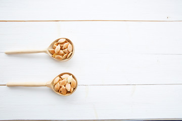 Pumpkin seeds in spoon on white wooden table with clipping path