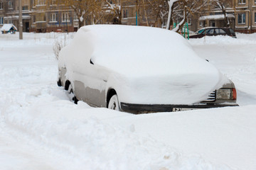 The car is covered with a thick layer of snow