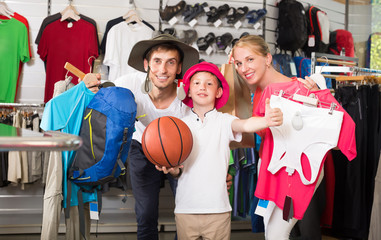 Adult parents with boy shopping hiking goods
