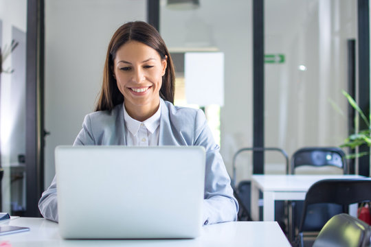 Beautiful Young Businesswoman In Formal Wear Using Laptop In Office