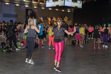 Fitness Workout in Gym: People doing Exercises in Class with Music and Teacher on Stage