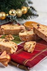 Traditional Italian Biscotti or Cantuccini cookies with hazelnuts, almonds, walnuts on a red-green napkin near the Christmas tree. Christmas and New Year baking.