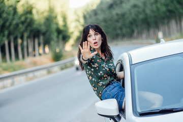 Woman peeking her body through the window of the car