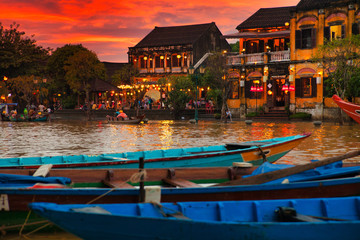 Traditional boats in front of ancient architecture in Hoi An, Vietnam.