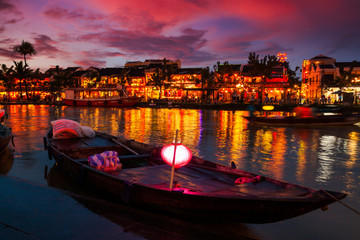 Traditional boats in front of ancient architecture in Hoi An, Vietnam.