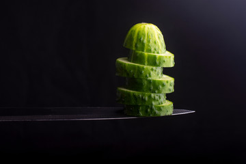 chopped cucumber on a knife edge