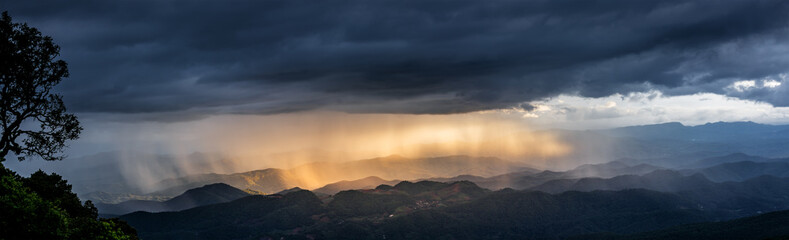 sunset sky with fog and rainy clouds raining over the Majestic mountains landscape