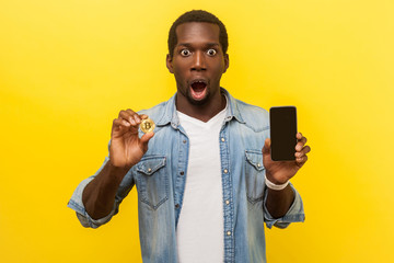 Cryptocurrency mobile app. Portrait of excited man with astonished shocked face expression wearing...