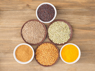 Mustard seeds, cumin, fennel, fenugreek, masala, turmeric on brown wooden background. Indian cuisine, ayurveda, naturopathy concept