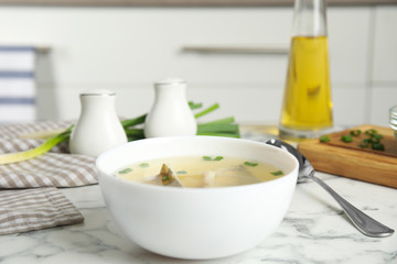 Delicious fish soup served on marble table