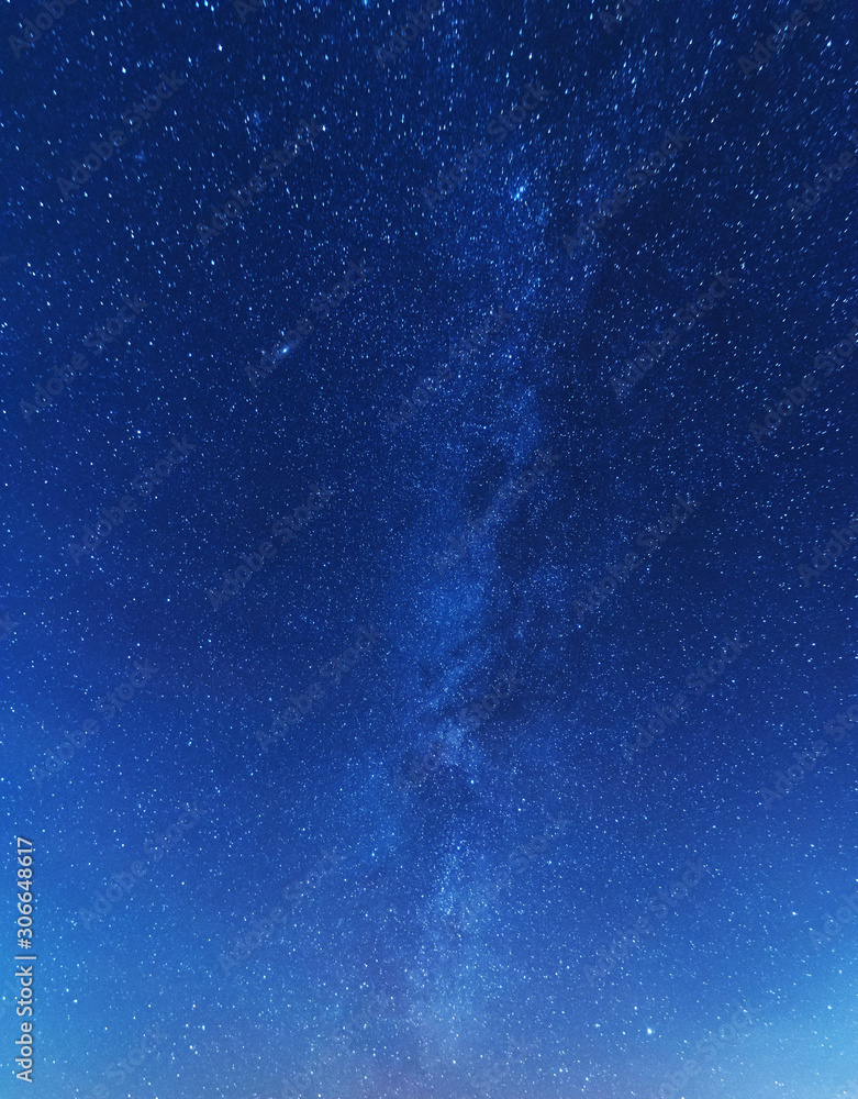 Wall mural a magical starry night on the river bank with a milky way in the sky and falling stars in the winter
