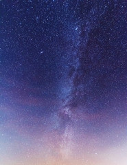 A magical starry night on the river bank with a milky way in the sky and falling stars in the...