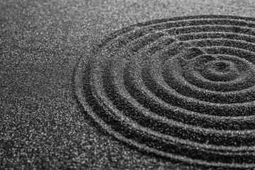 Fototapeta na wymiar Black sand with beautiful pattern, closeup. Zen concept