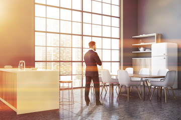 Man in grey kitchen with bar and table