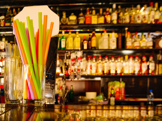 Bar counter and blurred background with alcohol bottles.