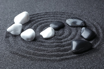 Stones on black sand with beautiful pattern. Zen and harmony