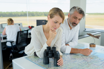 woman with binocular studying area blueprint