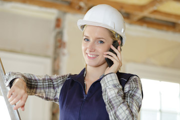 young engineer woman with safety hard hat talking on phone