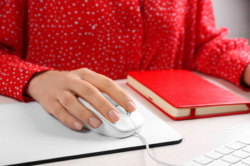 Woman using modern wired optical mouse at office table, closeup